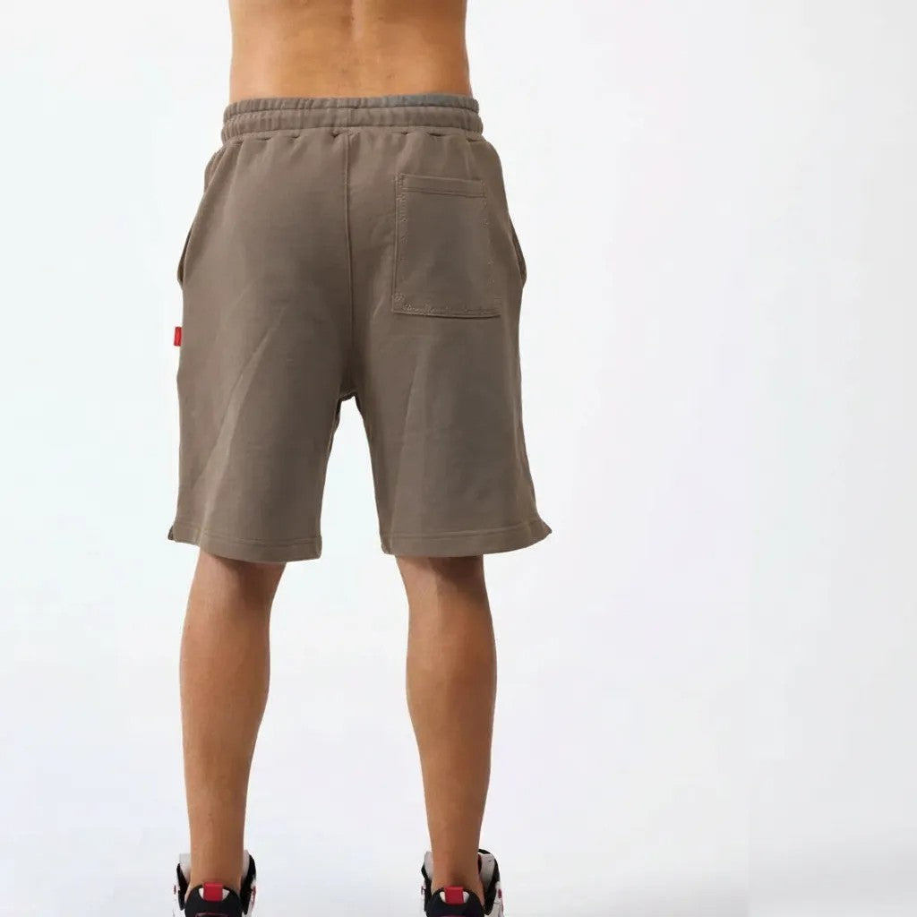 vallmountbotique beige cotton blend athletic shorts with distressed seams and embroidered logo. Relaxed fit with elastic waistband and drawstring.