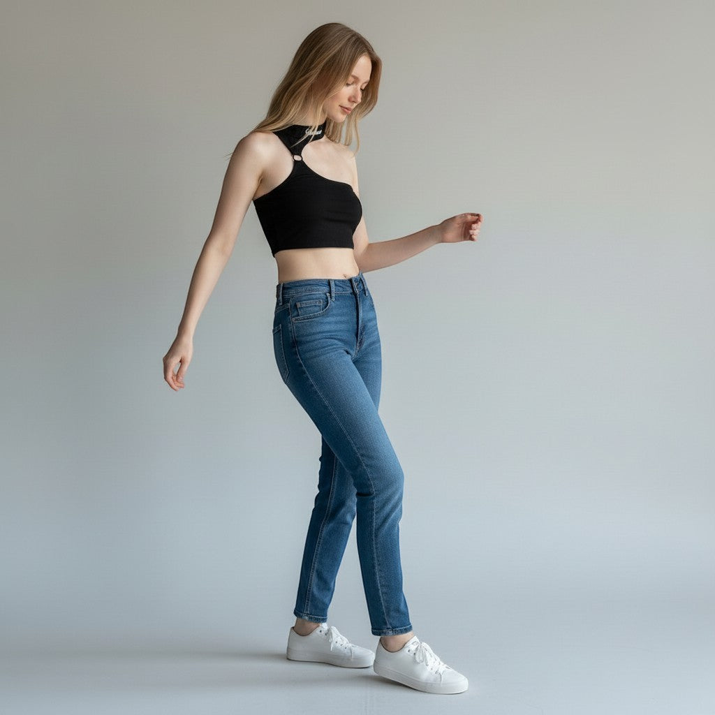 Vallmountbotique black one-shoulder crop top with metal ring detail and cutout, paired with blue jeans.