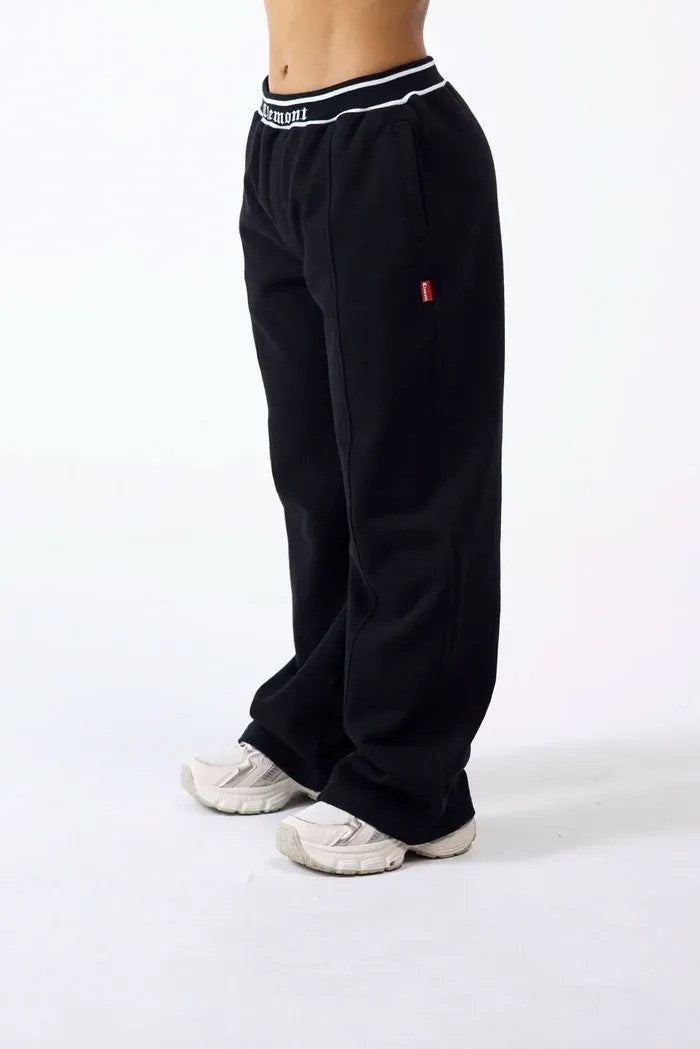 vallmountbotique black wide-leg track pants with branded elastic waistband and white stripe detail.