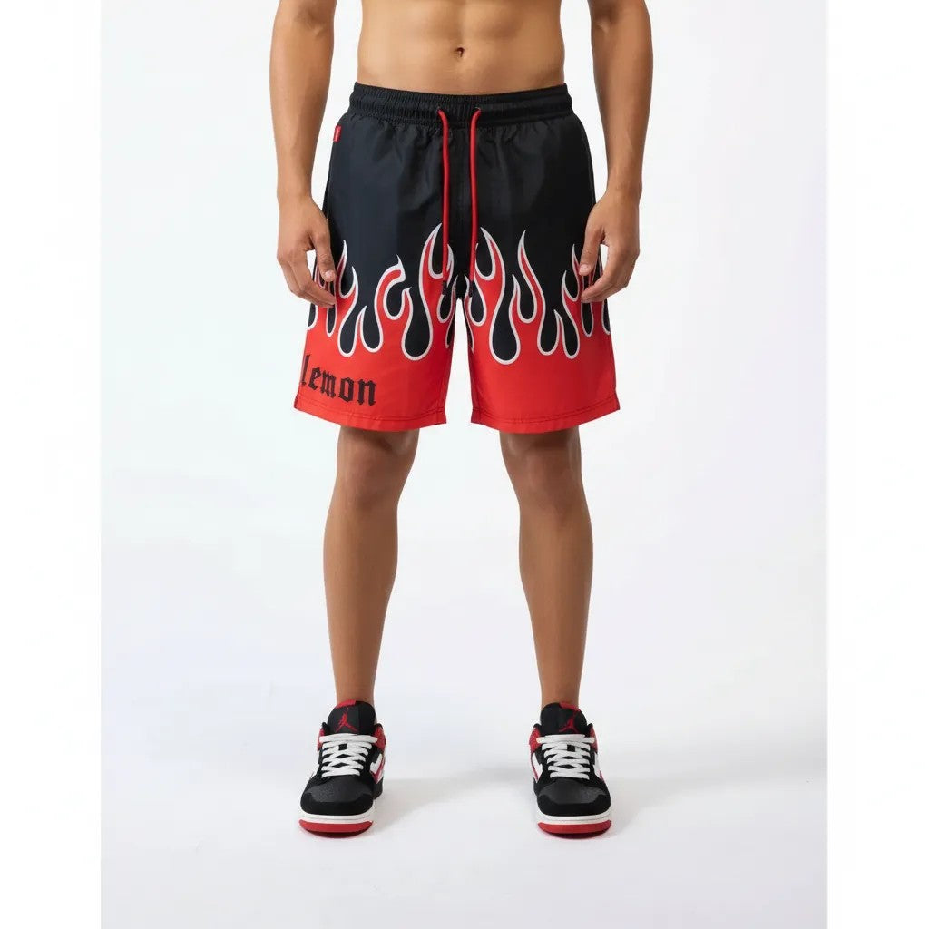 Vallmountbotique black swim trunks with red flame print and elastic drawstring waist. Features 'lemon' text.