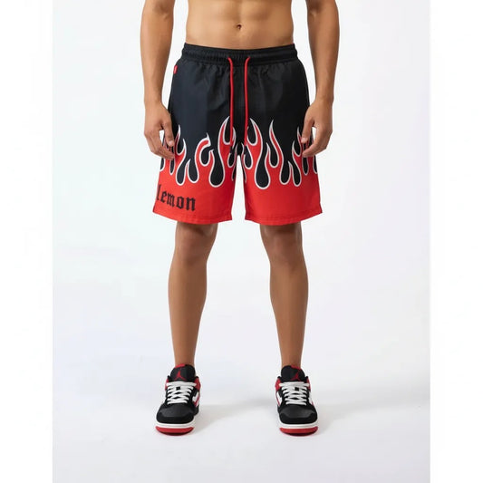 Vallmountbotique black swim trunks with red flame print and elastic drawstring waist. Features 'lemon' text.