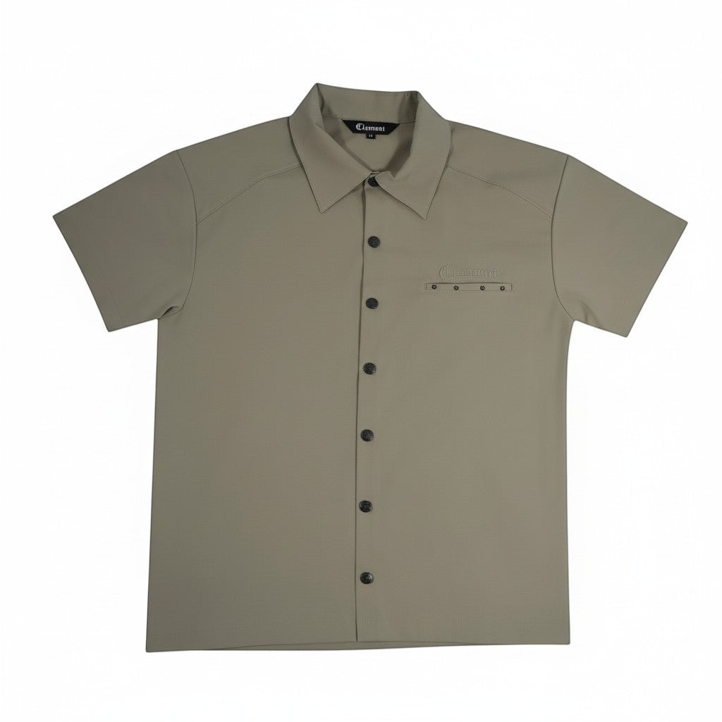 Vallmountbotique khaki short sleeve button-up shirt with embroidered logo on chest pocket and decorative grommets on back yoke.