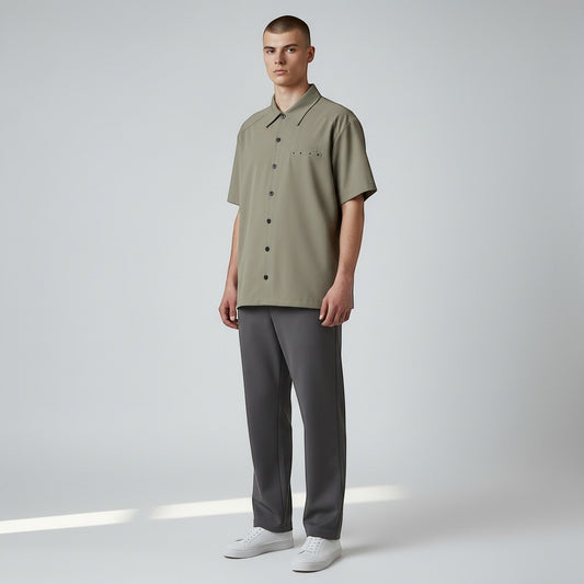 Vallmountbotique khaki short sleeve button-up shirt with embroidered logo on chest pocket and grommets on back yoke.