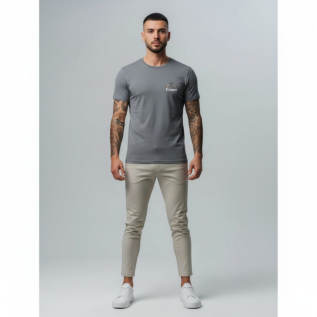 Vallmountboutique grey cotton t-shirt with ornate crown graphic on back and small logo on chest. Model wears slim-fit chinos and sneakers.